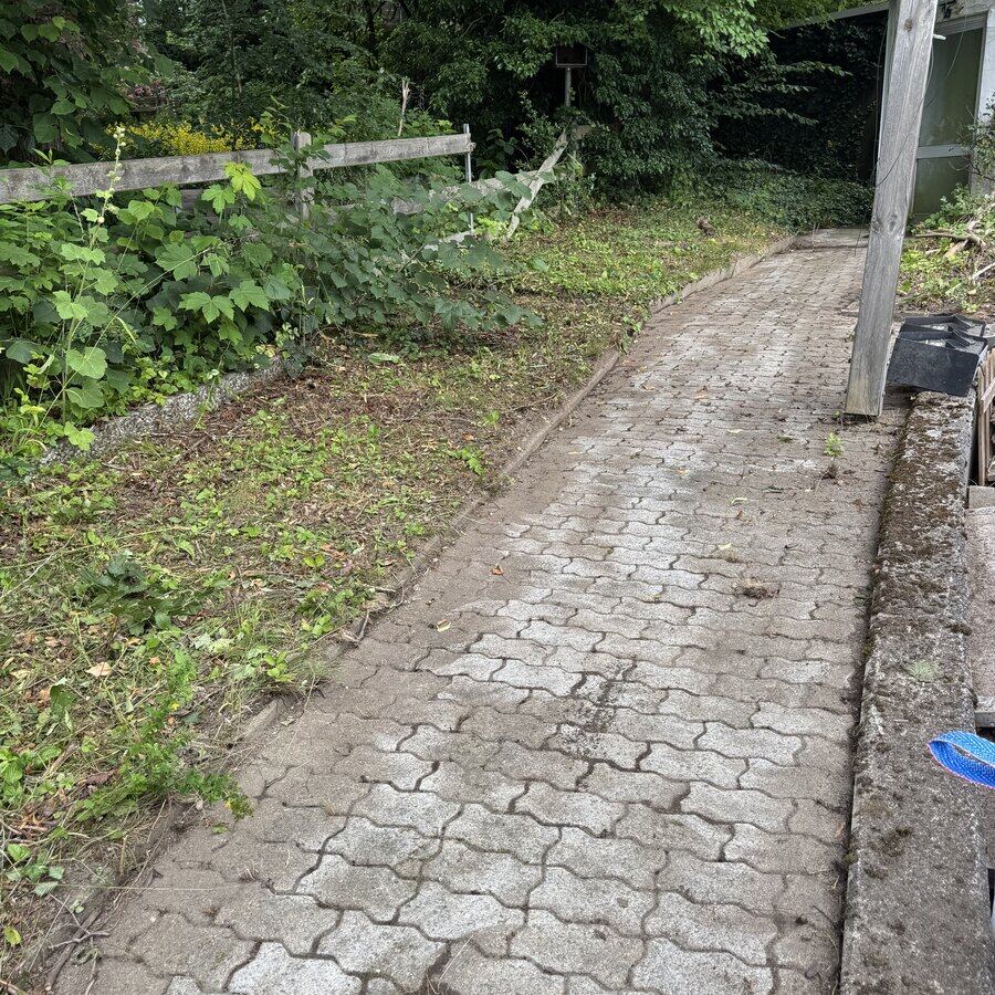 Derselbe Hang geräumt, gepflasterter Weg wieder frei
